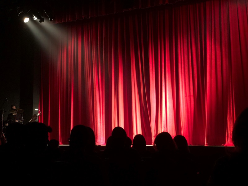 A warmly lit stage with dramatic curtains — the setting for a keynote that inspires radical hope