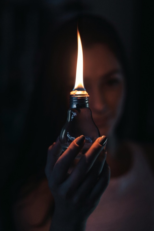 Hands gently holding a flame — the light you carry is already within you